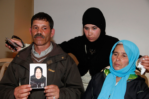 Lahecen El-Filali holds a photo of his daughter during a news conference in Rabat