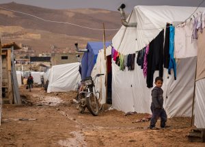 A young Syrian refugee walks past tents at the Al-Nihaya camp in the eastern Lebanese town of Arsal on October 23, 2014. With more than 1.1 million Syrian refugees, Lebanon has the most refugees per capita in the world, and the influx has created some resentment in a country of four million already facing economic and political challenges.  AFP PHOTO / Maya Hautefeuille        (Photo credit should read Maya Hautefeuille/AFP/Getty Images)